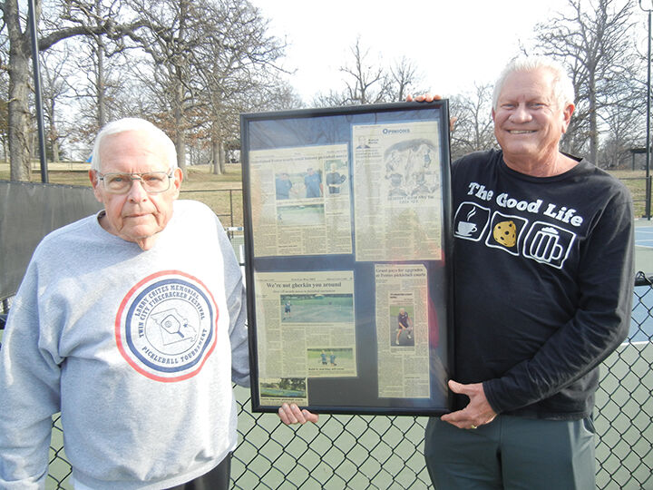 Jim Berger of Crystal City, left, and fellow pickleball enthusiast Brian Bass of Festus with framed newspaper clippings of previous pickleball stories, which Berger uses when promoting the game.